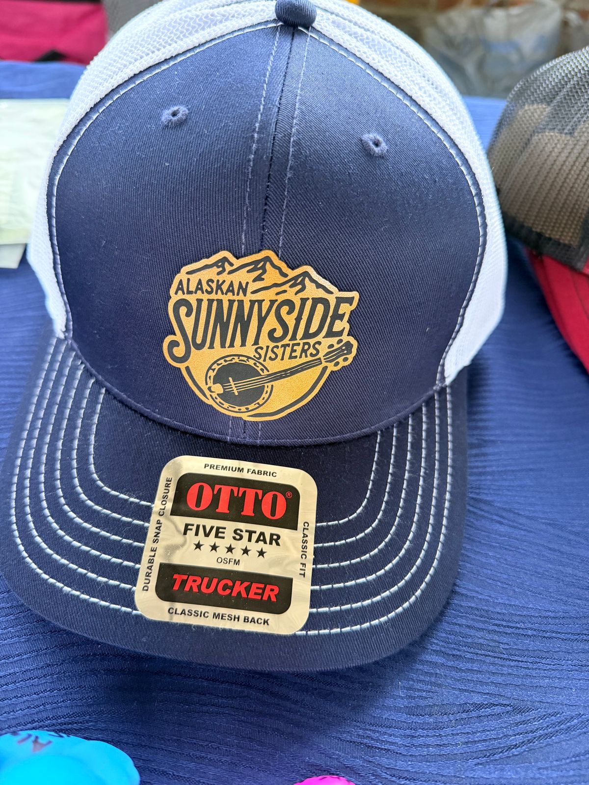 Alaskan Sunnyside Sisters Leather Patch Trucker Hat (Red/Charcoal or Navy/Gray)