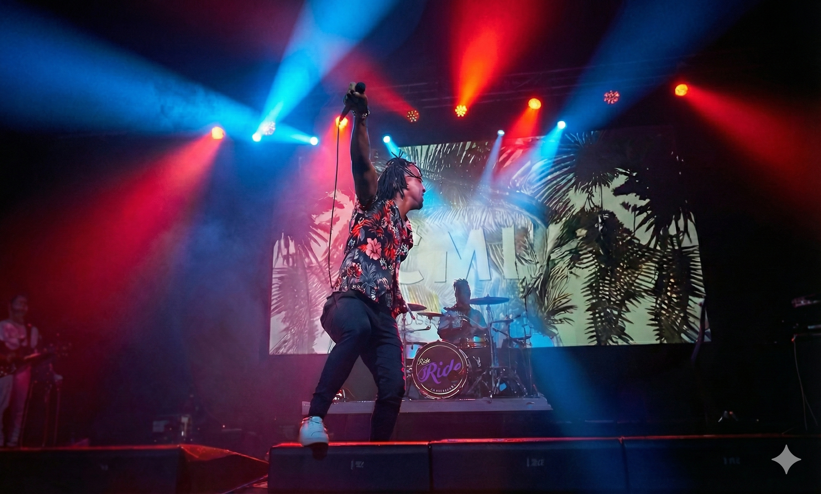 Cellus performing with a live band under red and blue stage lights