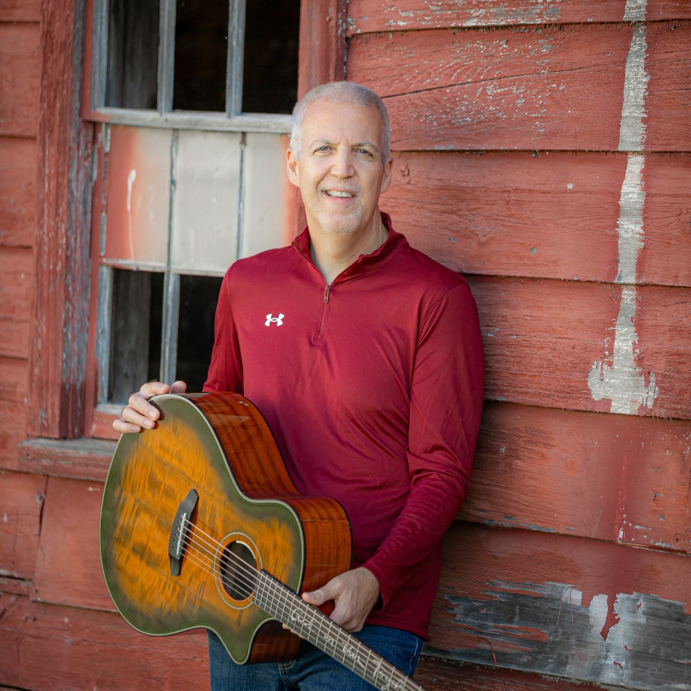 Mike Lucey Leaning on a Red Barn with Breedlove Acoustic