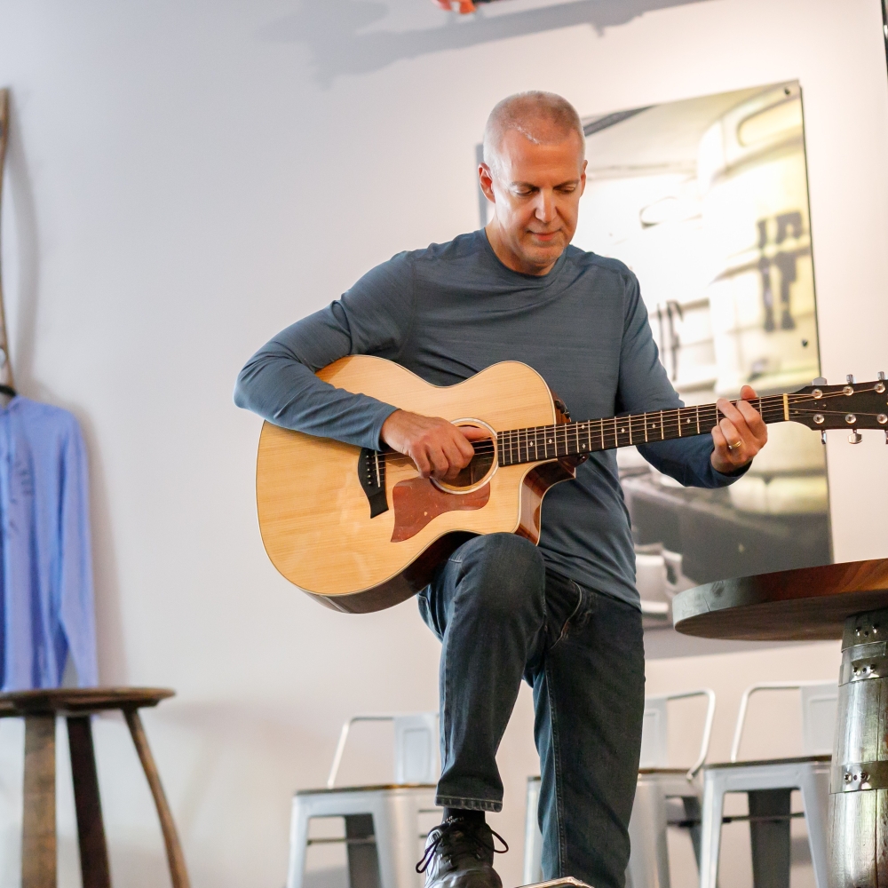 Mike Lucey with Guitar in a Bar Room
