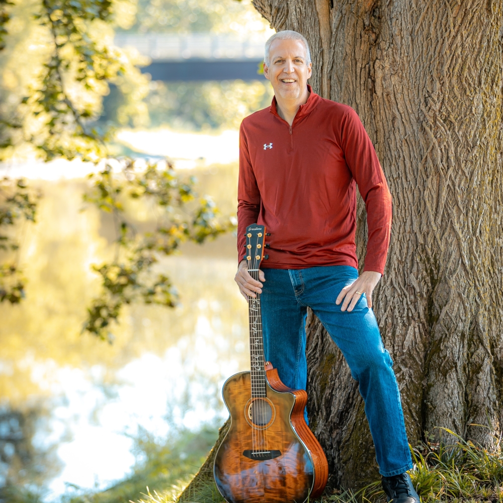 Mike Lucey with a Breedlove Acoustic Guitar Next to a Tree