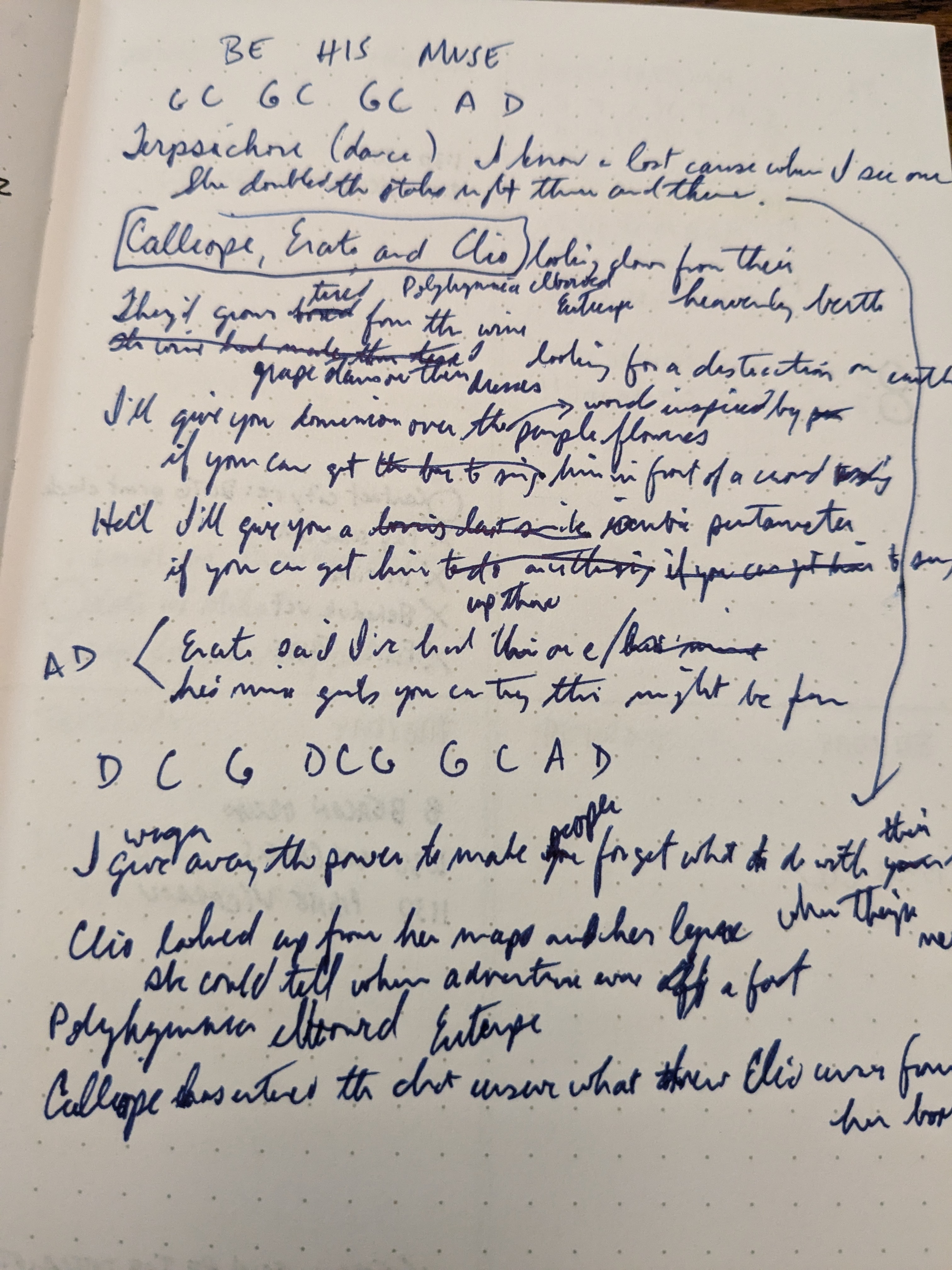 A photo of a nadwritten page of lyrics, with words crossed out, arrows drawn to other sections, and chord listings