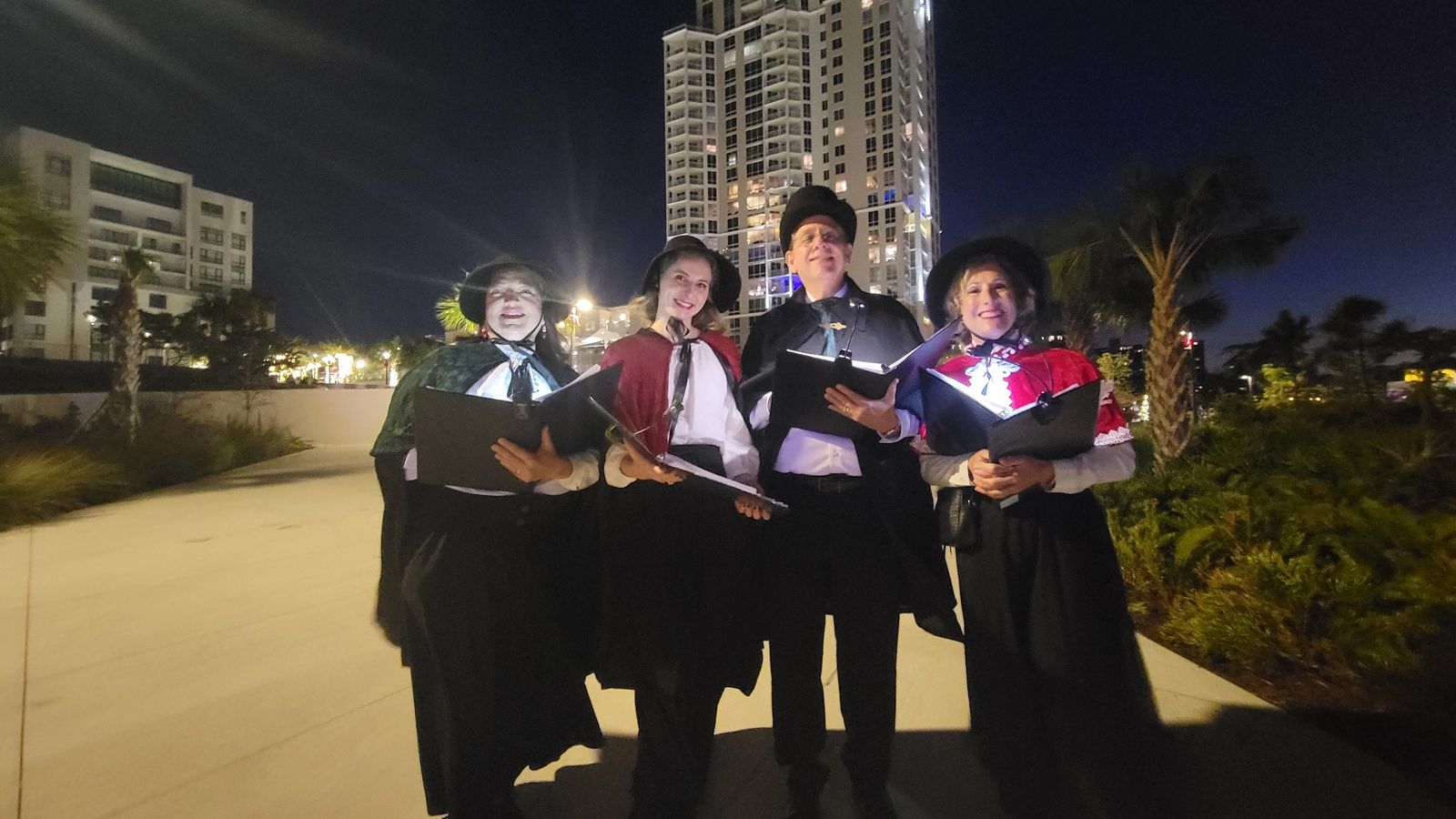Victorian carolers performing outdoors at night in Tampa Bay