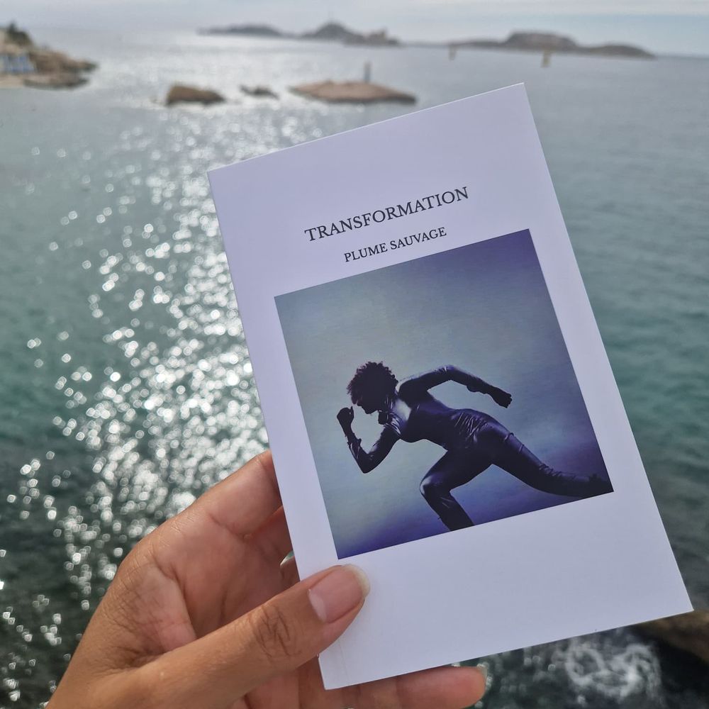Le livre TRANSFORMATION tenu face à la mer
