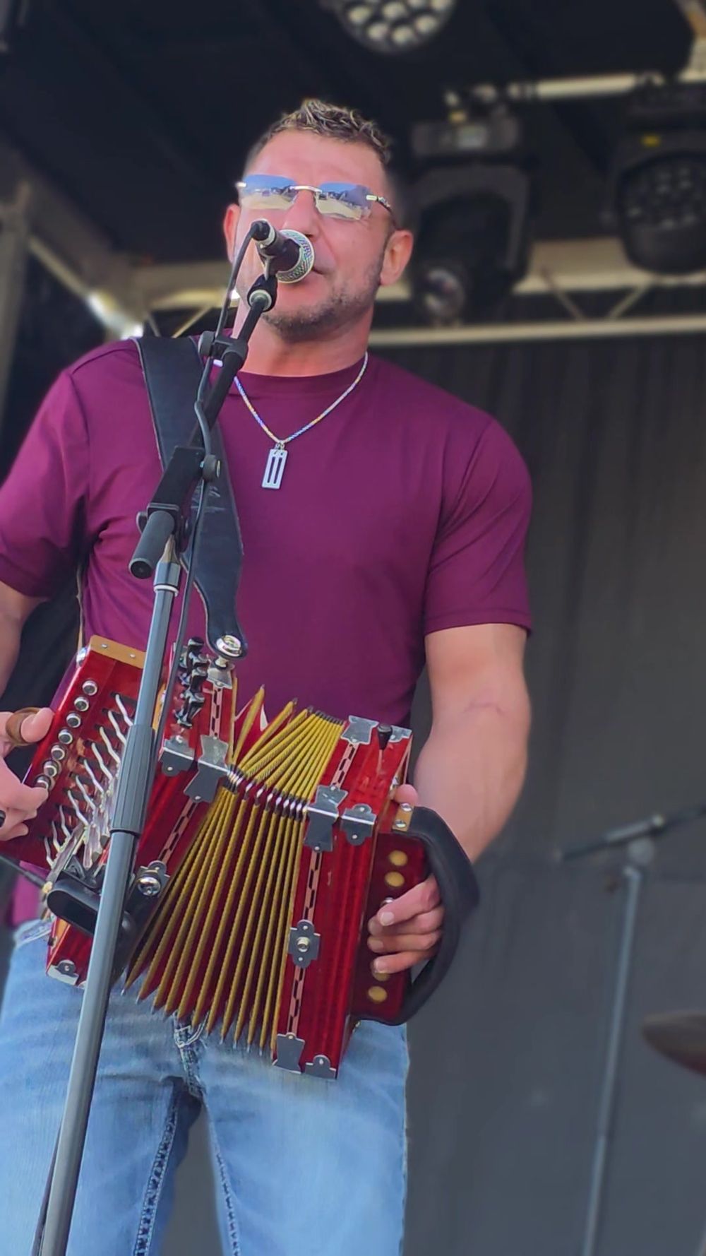 Man singing at a mic holding accordion in louisiana.
