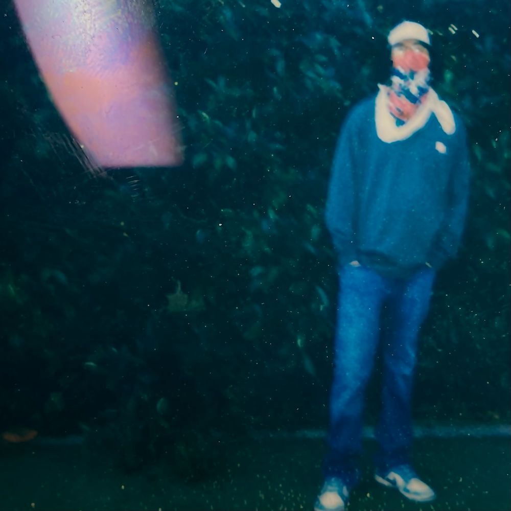 Twelve Clouds wearing a custom two-tone blue hoodie with 12 clouds on it and an orange beanie.