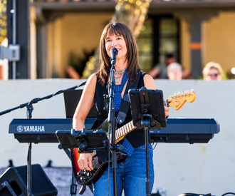 PretendAZ singer and guitarist performing live at an outdoor concert