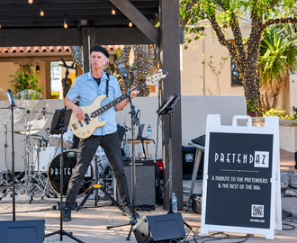 Tom O'Shea playing bass with PretendAZ during a live 80s rock and dance performance.