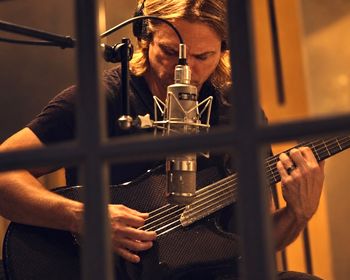 Chris Green playing guitar in the recording studio during the making of Mirror, his rock ballad released through Crimson Star Records in October 2026.
