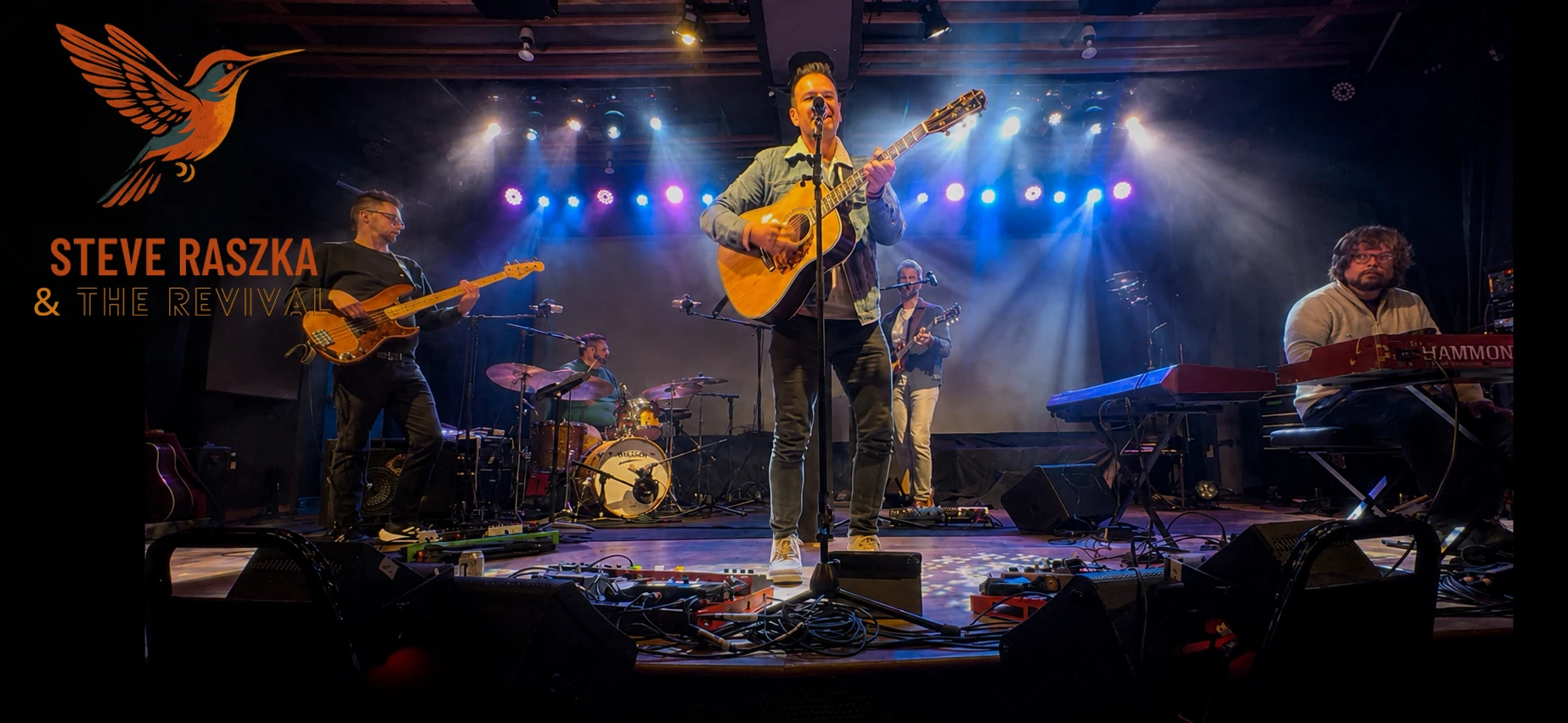 Steve Raszka & the Revival performing at Radio Artifact, with the band’s hummingbird branding