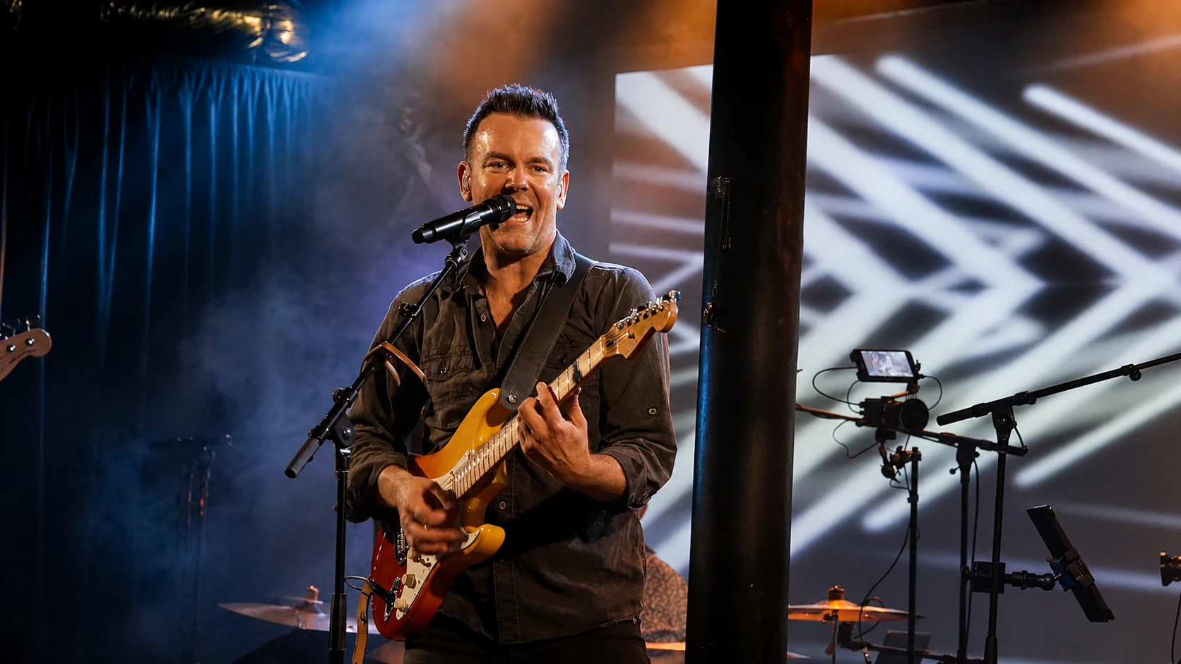 Steve Raszka singing and playing guitar on stage