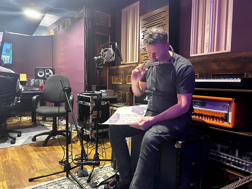 Al Drury recording acoustic music in a studio session.