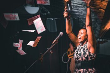 Macharia spraying fake money during the performance of her song "money"
