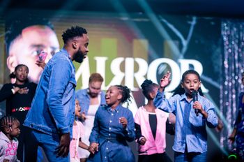 Bj'orn Pierre shares a moment with children on stage at Mirror Man 2: The Concert

