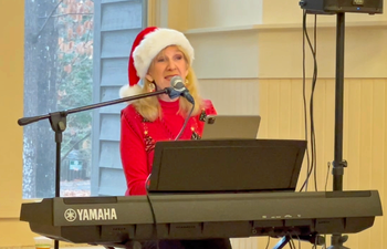 Ginny entertains guests at Walker Nature Center holiday party
