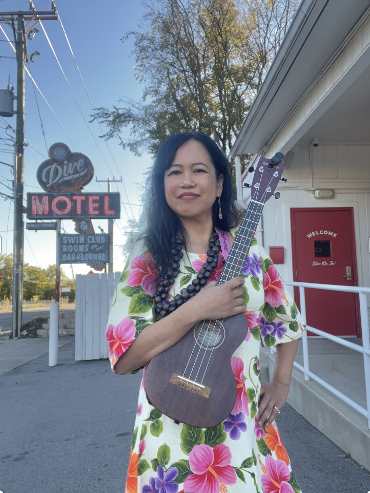 Silvia Passiflora, Southern Gothic Folk poet-songwriter, holding an ukulele outside The Dive Motel in Nashville, Tennessee, a retro boutique venue known for its weekly original songwriter showcase.