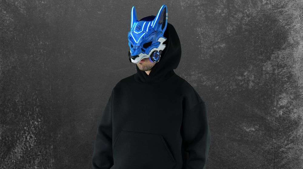 Aspiire artist wearing a blue cyberpunk wolf mask and black outfit on a dark textured background