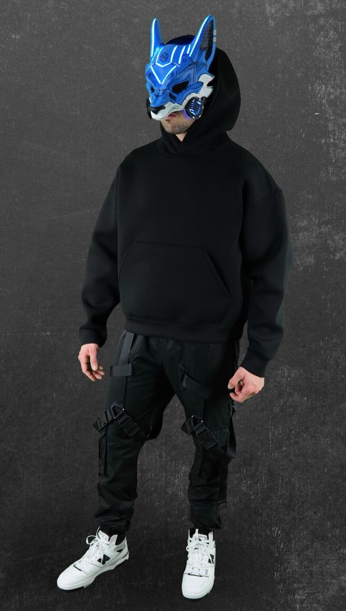 Aspiire full body artist portrait wearing a blue cyberpunk wolf mask, black hoodie and techwear pants on a dark textured background