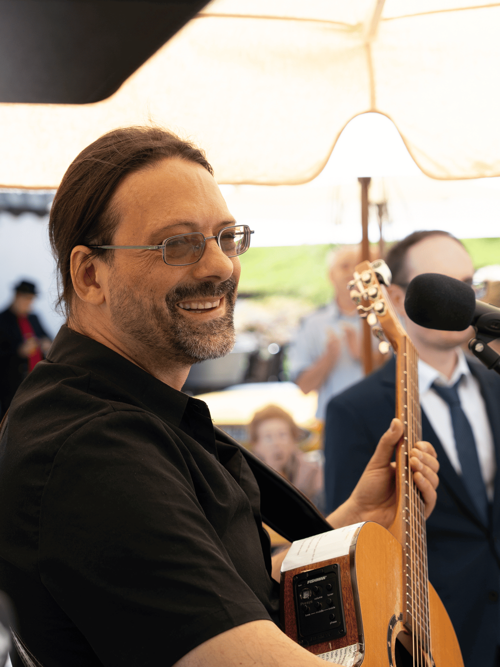 Hochzeitssänger Andy Wilsing lachend bei einem Outdoor-Auftritt – Live-Musiker für Hochzeitsfeiern und Events im Freien