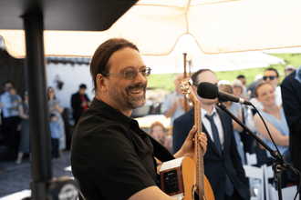 Fröhlicher Hochzeitssänger Andy Wilsing bei einem Open-Air Auftritt – Live-Musik für Sektempfang und Gartenhochzeiten im Freien.