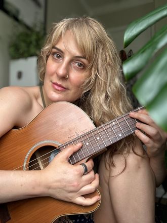 Maria Sierra playing acoustic guitar
