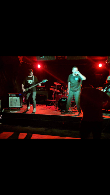 Adrian playing bass guitar alongside Andrew, Tyler, and Logan with the metal band "Descent of a Tyrant" in 2018.
