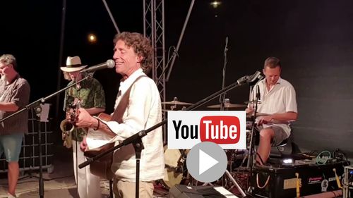 Marco Augusto Picknickkonzert, singend und Gitarre spielend auf Bühne mit Band (Saxofon, Drums, Bass). Italienische Songs, Italopop à la Ramazzotti, open air in der alten Festung Germersheim