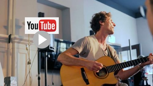 Marco Augusto in der Hemingway Lounge Karlsruhe unplugged an der Gitarre, während seiner Udo Lindenberg-Show mit dem Song "Mein Ding" - hat eine schöne Weste an, strahlend singend!