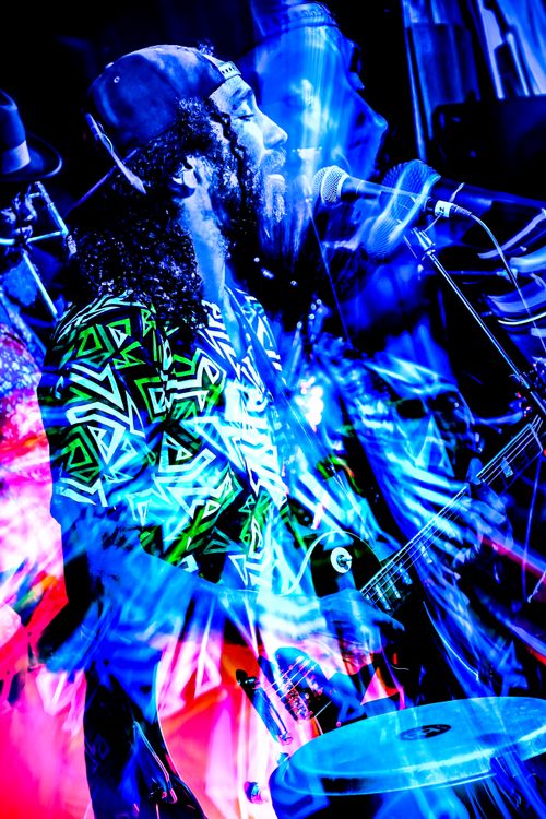 Adrian Xavier performing live onstage under blue lights