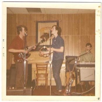 Apocalypse at the Moose Hall, Spring 1970 One of my favorite gigs ever, bar none, was playing for the retards at the Moose Hall. Now I know it's politically incorrect to call kids with severe learning disabilities and limited IQs retards, but that's what we called them, and we loved them! We'd get our moms to drive us to the Moose Lodge and the 'tards would have a dance and we'd play for 'em. They were the best audience ever. They loved us, and we'd play our butts off for them. Note Moose wall-hanging in background. left to right: me (on my Gibson SG, the good guitar); David Meyer slapping the tambourine; and Larry Gallat on Farfisa.
