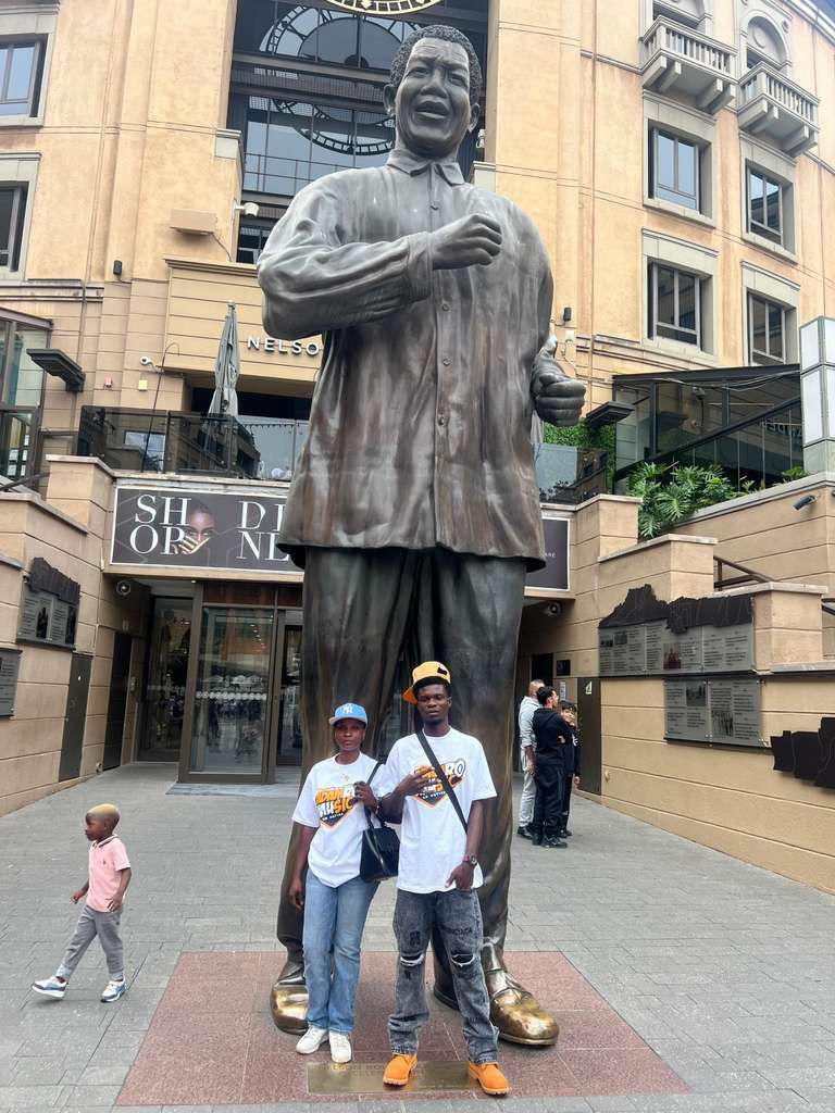 Adam Ro Music Ltd team members wearing company-branded shirts at Nelson Mandela Square in Johannesburg, South Africa.