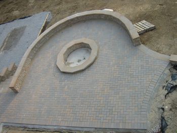 mid level patio with fire pit picture taken during construction
