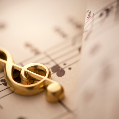 Treble clef in gold on sheet music