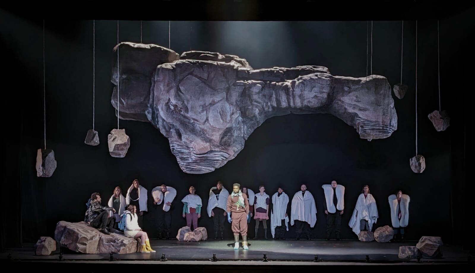 The chorus in a line beneath a floating rock
