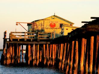Old wooden Seafood processing building at the end of a wharf.