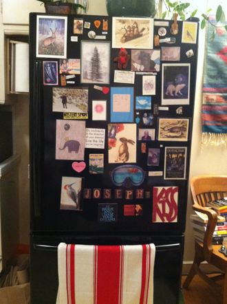 Refrigerator with many photos and magnets.