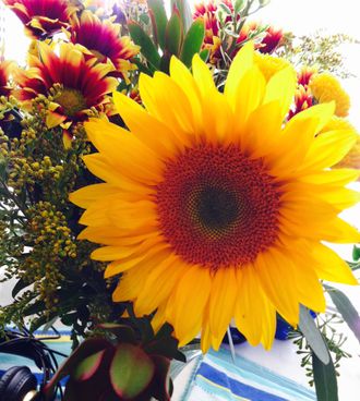 A bouquet with a big yellow sunflower.