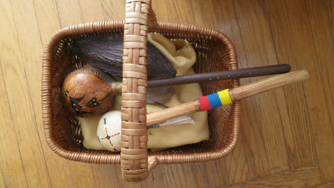 A basket with two indigenous rattles, and a chocolate pod. 