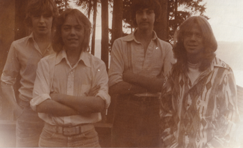 This is the very first photograph of Jon as a musician. This was Jon's first band "The IOSIS Band". They had just started playing music together when this photo was taken. This is also the first time Jon attempted to grow his hair long! Jon is second from the left.
