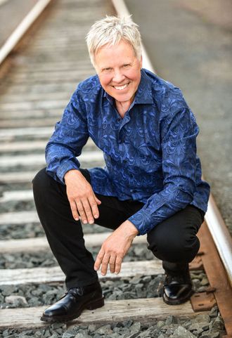 Jim Gerber smling on railroad tracks 