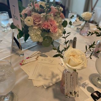 Bridal shower table decor with floral centerpiece and game cards at a Boston area harp performance