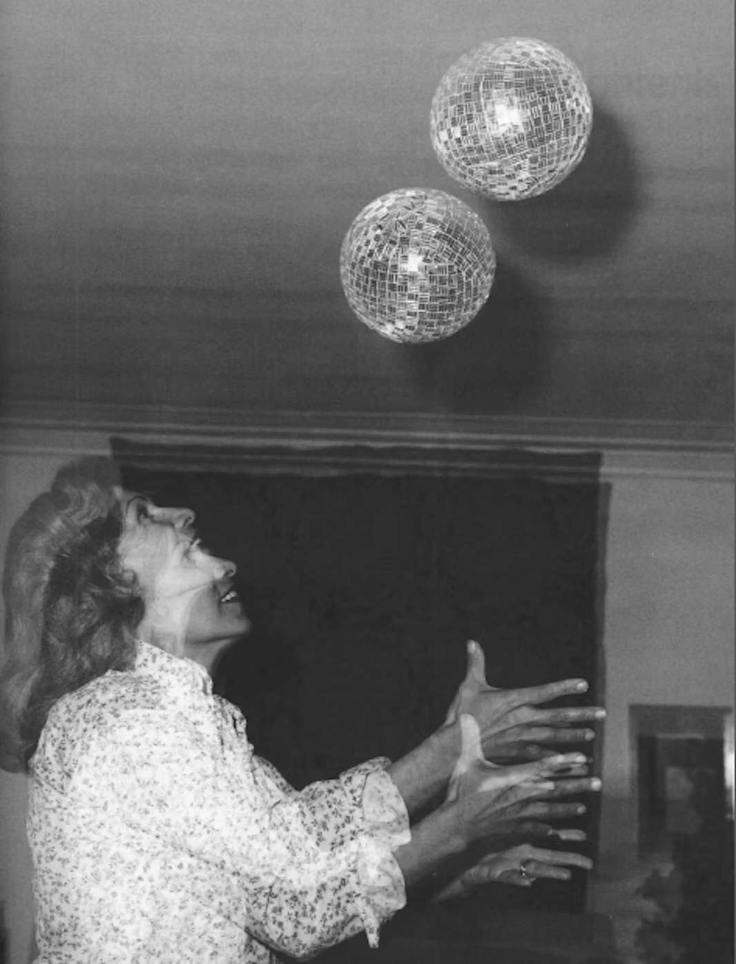 The artist, Monir, photographed with her mirrored artwork, from her website.
