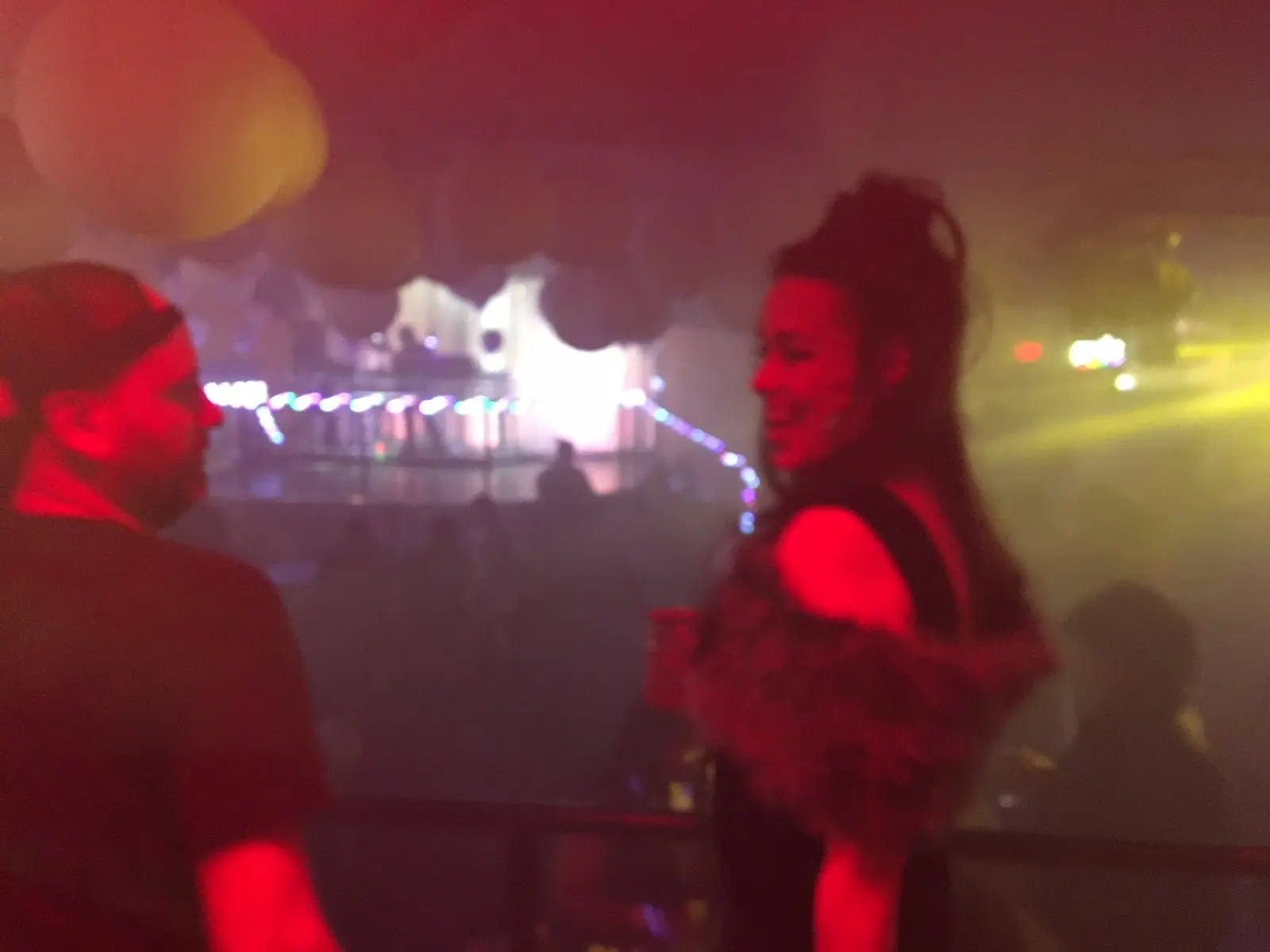 A candid, close-up photo of Jill Jones and Jeremy Gloff talking and laughing at the Interbelt nightclub. Jill has a wide, genuine smile.