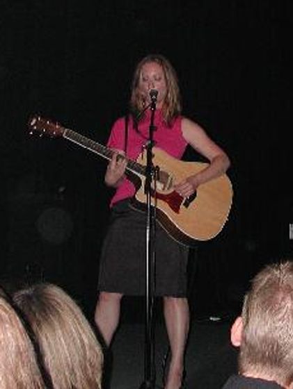 Musician Leslie Nuss playing guitar live.
