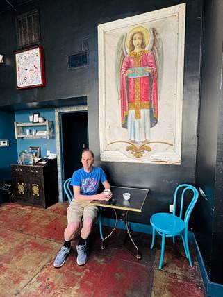A person sitting at a table in a room with a painting on the wall

AI-generated content may be incorrect.