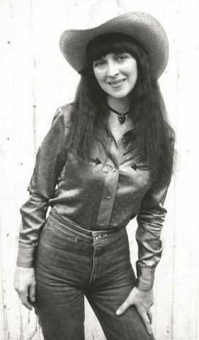 Cowgirl in the alley. Living on singer-songwriter gig money in Chicago kept me in a grim neighborhood.  I wrote lots of songs about missing my farm town roots.  The shirt was bright red satin.  Photo by Billy Prewitt
