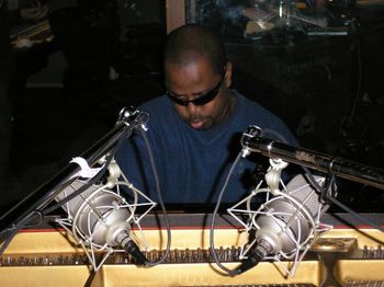 Minister Vincent on the piano at Different Fur Recording Studio

