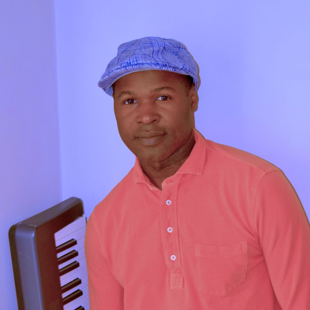 Kevin Julien producer profile picture standing in from of keyboard