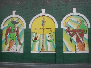 Anubis, lord of the underworld, weighing the human heart against the Shu feather, representing Maat (Truth).
