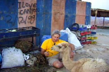 During production of "Egypt - Karnak to Coral Reef," PCD and a young camel have lunch together after a hike through Coloured Canyon, in the Sinai. Randy Saletnik Photo
